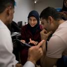 Woman in hajib and two men converse