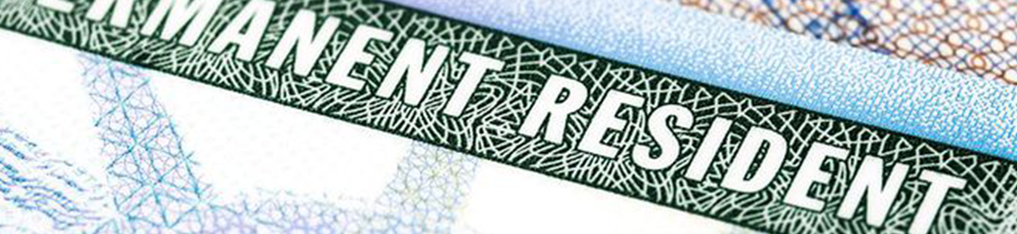 magnifying glass over green card, says permanent resident 