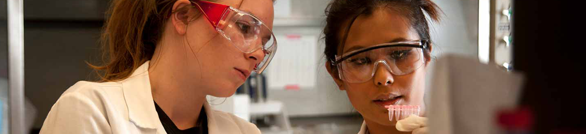 two girls looking at test tubes 