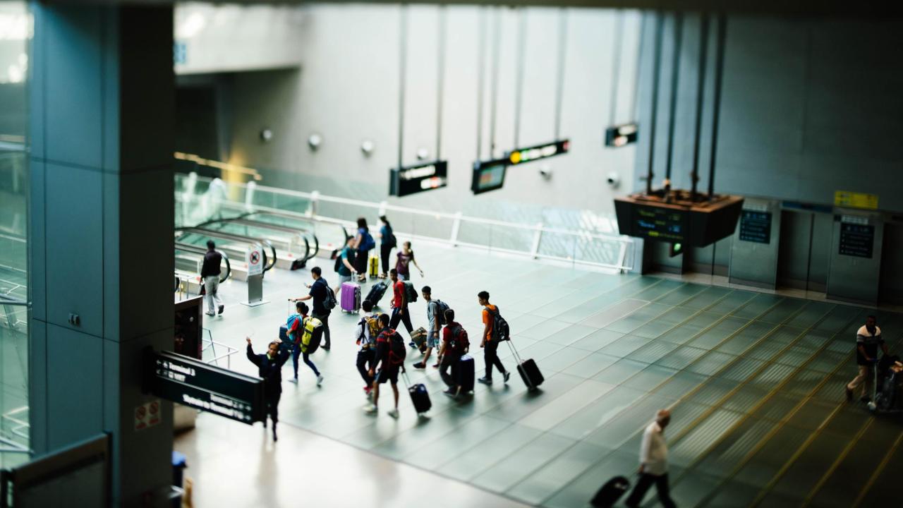 Travelers walking around airport with suitcases