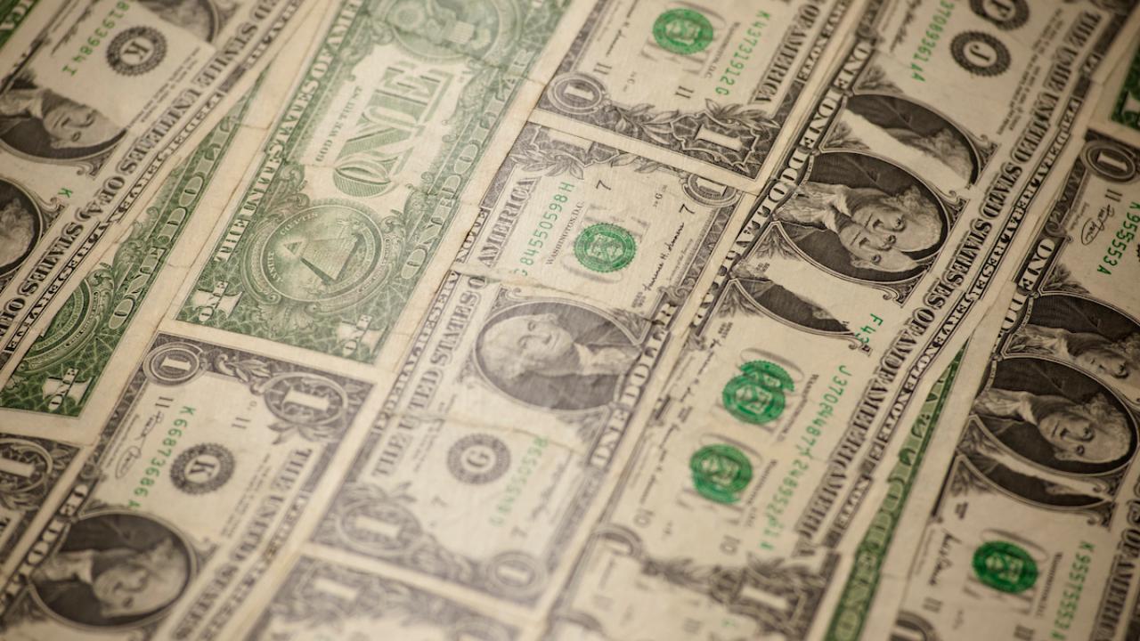 A series of dollar bills are spread out.