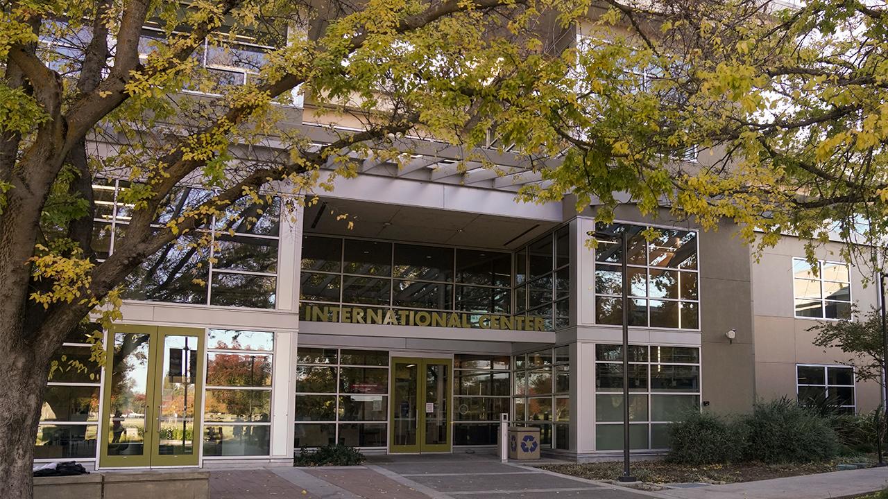 The exterior of the International Center main entrance with the sign that reads International Center on a sunny fall day.