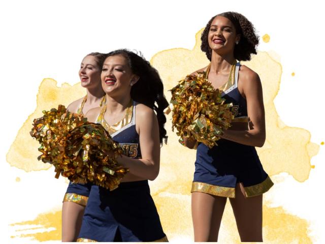 Three cheerleaders in blue and gold uniforms smiling and holding pom-poms.