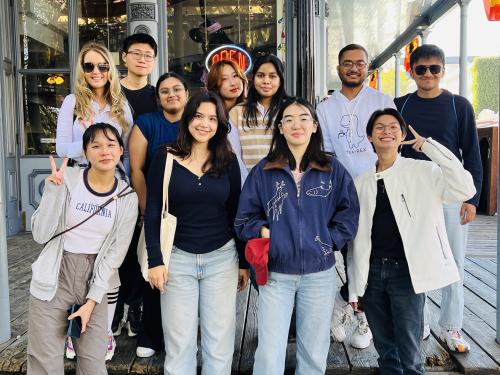 Eleven students smile at the camera in a group photo.