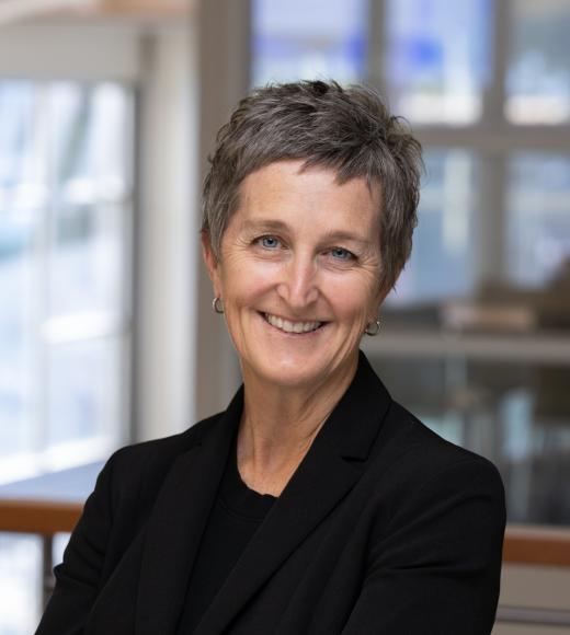 Karen smiles in a black shirt and blazer in the International Center.