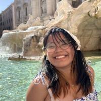 Photo of Keona Malaya in front of a large stone fountain.