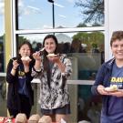 Students holding out cake to share
