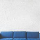 blue couch against white wall 