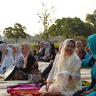 women sitting with their heads covered, talking 