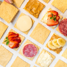 crackers with different toppings like banana and strawberry and salami