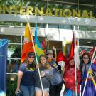 women with international flags in front of the international center 