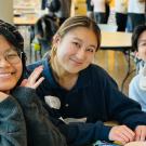 Three students smile at the camera.