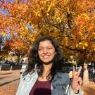 Photo of Suhani Shokeen outside with fall foliage in the background.