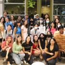 A group of students gather for a group photo, some in Halloween costumes, some in casual street clothes. 