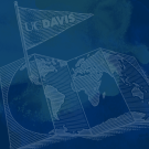 A transparent image of an unfolded map of the world with a UC Davis flag pinned on Davis in California sits on on a blue background.