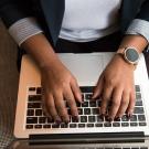 Hands typing on laptop