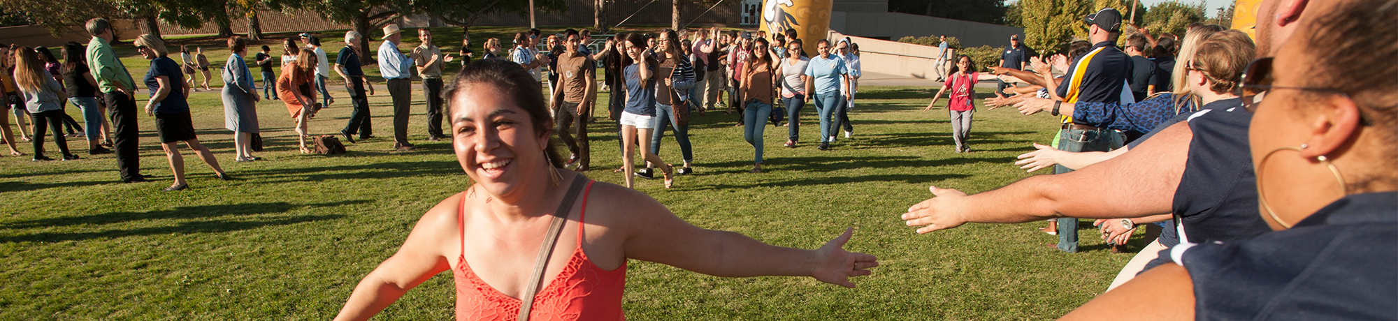 girl running and high-fiving students 