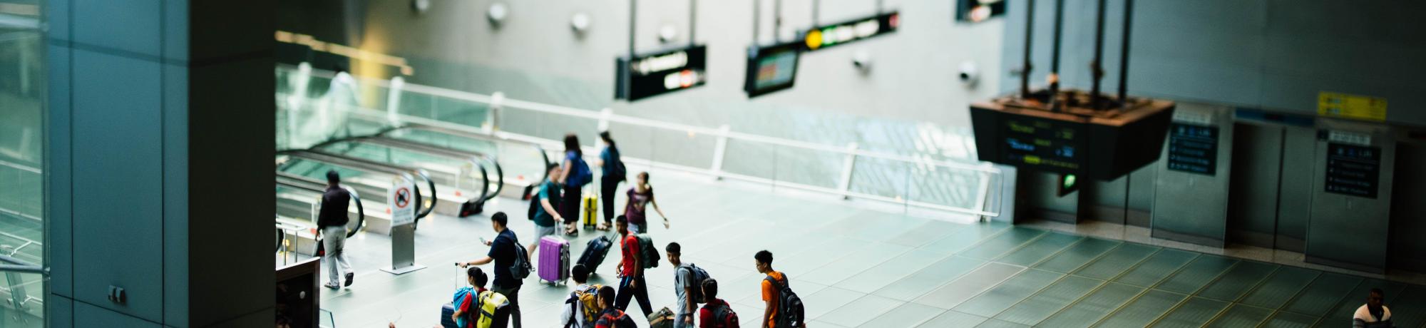 Travelers walking around airport with suitcases