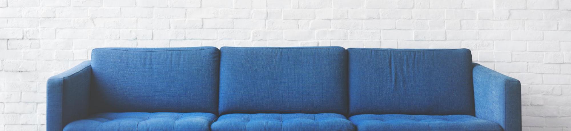 blue couch against white wall 
