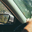hand on steering wheel and side mirror