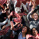 group of people looking in the air with hands up