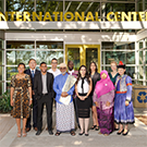 group of people in festive clothes standing in front of the international center